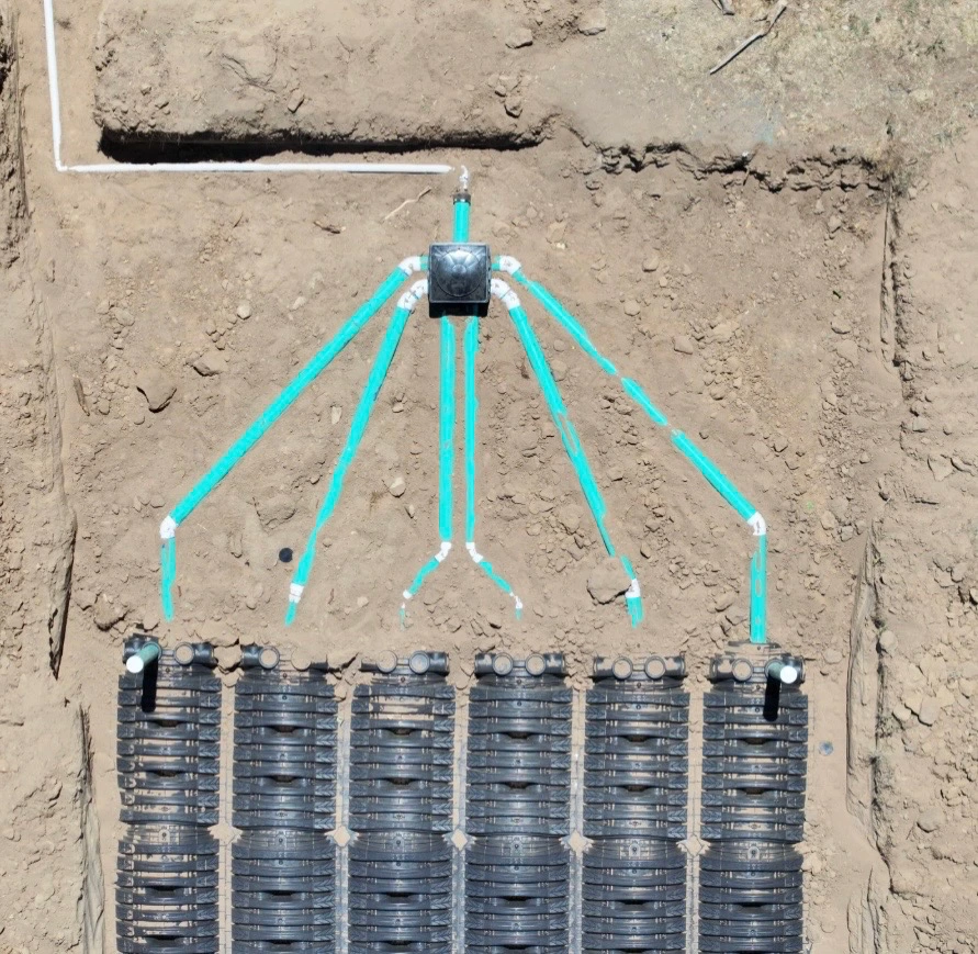 Overhead drone shot of an engineered Infiltrator chamber leach field and distribution box manifold in Boulder County